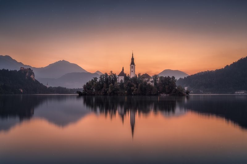 before sunrise, bled, blue, blue hour, calm waters, calmness, castle, church, church tower, cliff, clouds, forest, hills, island, lake, lake bled, lights, morning, mountain range, mountains, outdoors, reflections, rock, serenity, silence, sky, slovenia, s Awakening at Lake Bled фото превью
