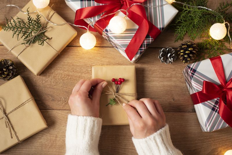 christmas, flat lay, present, woman, holiday, table, box, wrap, handmade, top, hands, view, red, pack, xmas, stylish, ribbon, craft, white, new, decoration, modern, wooden, creative, design, hand, winter, year, background, wrapping, festive, package, pack Woman\'s hands tying the bow on vintage present on rustic background.  фото превью