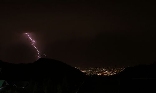 Гроза в горах на фоне города.